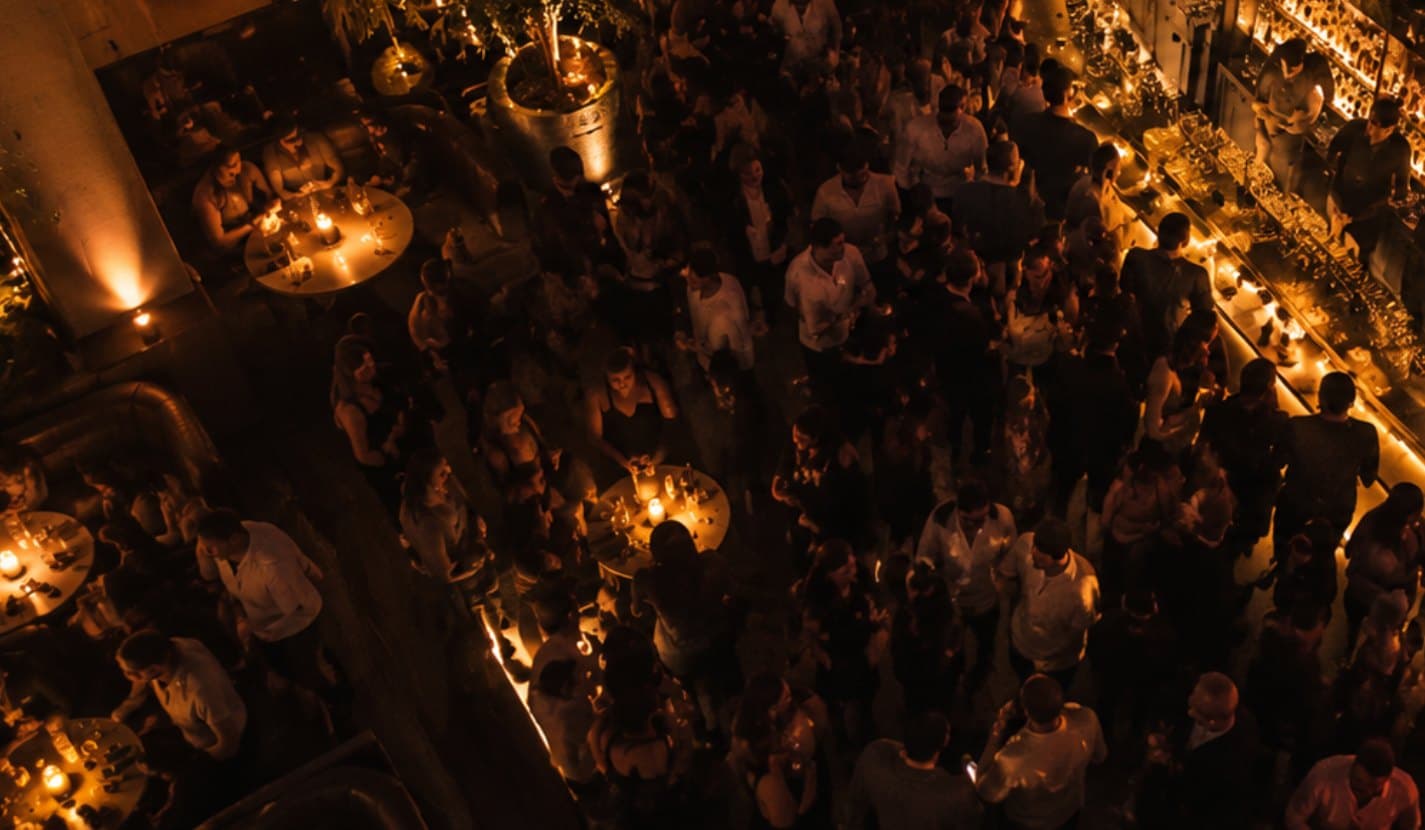 Fullsatt bar och nattklubb sedd ovanifrån med gäster vid baren och borden