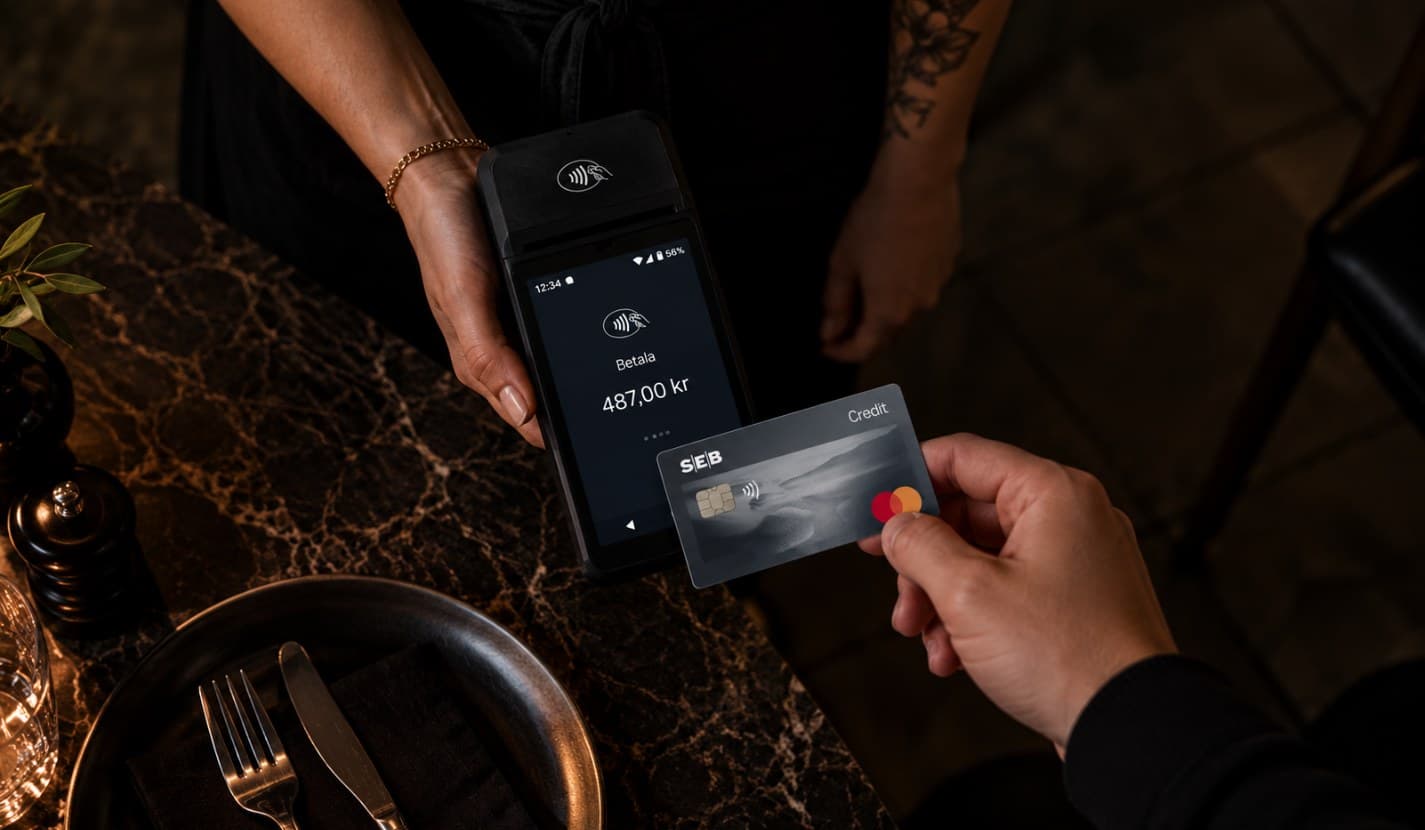 Gäst blippar kortet mot Ovrios handterminal vid bordet